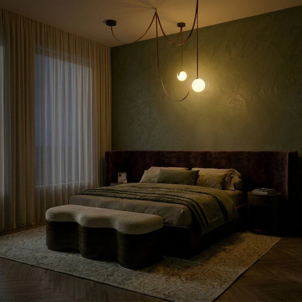 A lit Clérachic leather and glass chandelier glows softly with two globe shades above a bed in a dim green bedroom.