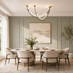 This Clérachic pendant hangs over a laid dining table in a sage-green panelled room with an abstract landscape print.