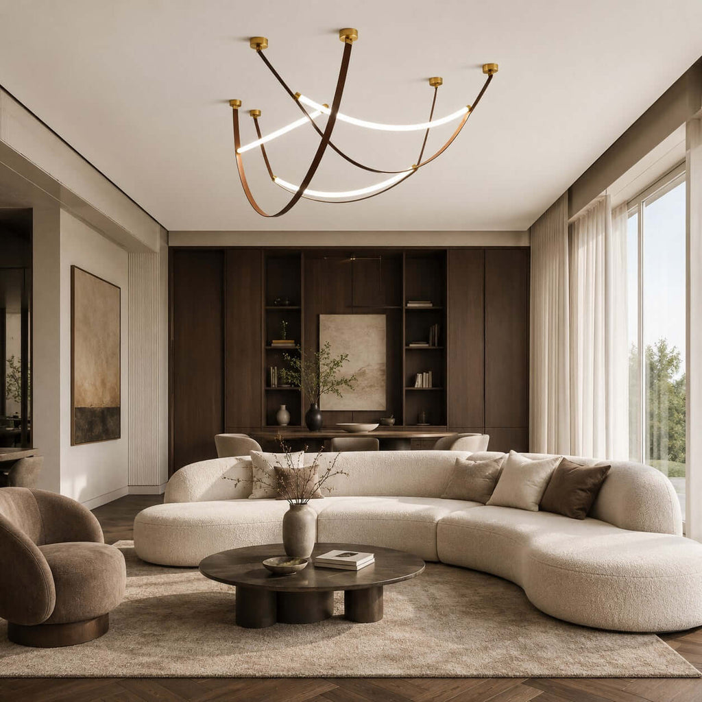 Clérachic loop pendants in a three-piece set, hung high over a curved cream sofa and a low round table in a living room.