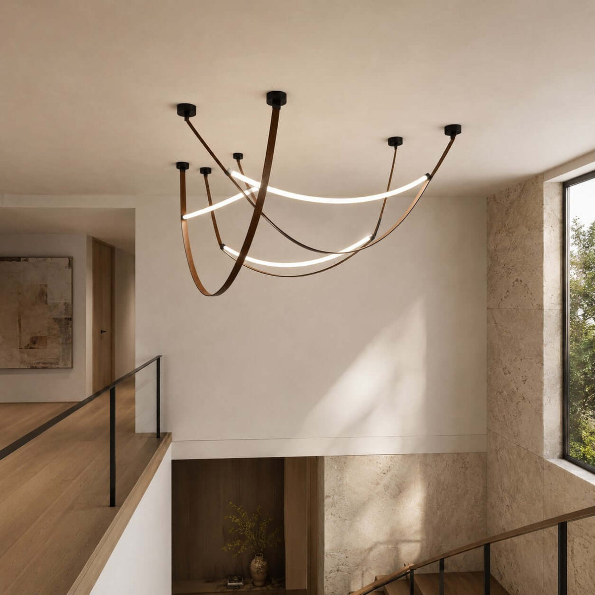A three-loop Clérachic pendant set in black and brown seen from a stair landing, with a window and a glass balustrade.