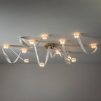 The 12-head Clérachic Leather Strap Chandelier in white leather with a brass canopy, spread wide across a ceiling.