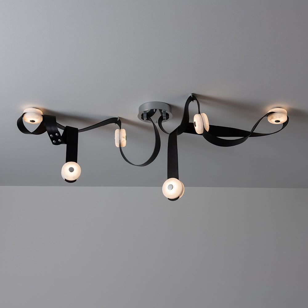 Side view of the 6-head Clérachic Leather Strap Chandelier in black leather, alabaster discs lit along the strap.