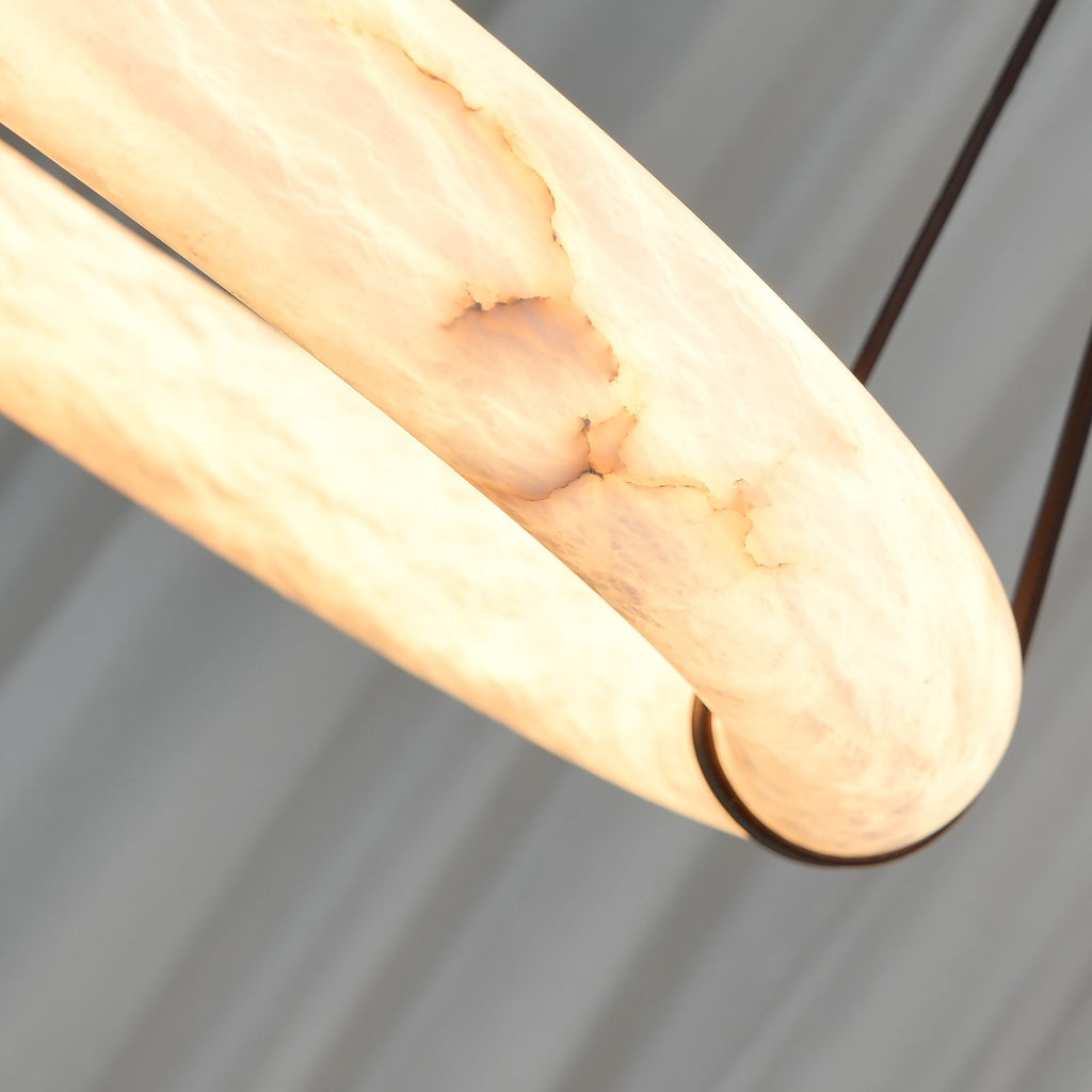 The lit Clérachic alabaster ring in close-up, the stone turning amber as its veining reads as pale gold striations.