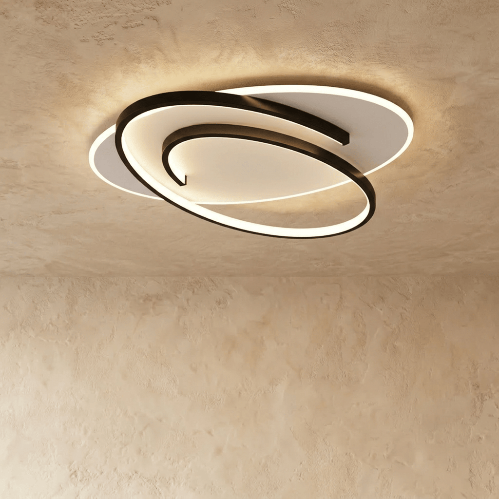 Clérachic wider oval flush ceiling light with a swirling black frame and a glowing white diffuser on limewash.