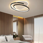 Clérachic oval ceiling light with a swirling black frame above a bed, slatted wood wall and sheer curtains.