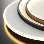 Clérachic close view of the stepped black rings and the glowing white diffuser disc on the flush ceiling light.