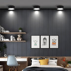 Clérachic three black round surface-mounted downlights above a grey panelled wall in a teenager's bedroom with shelves and a desk.