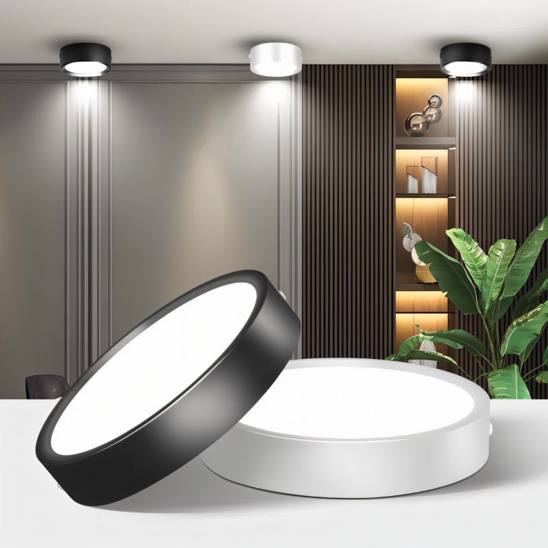 Clérachic black and white round surface-mounted LED downlights close up in the foreground, with the same lights on a room ceiling behind.