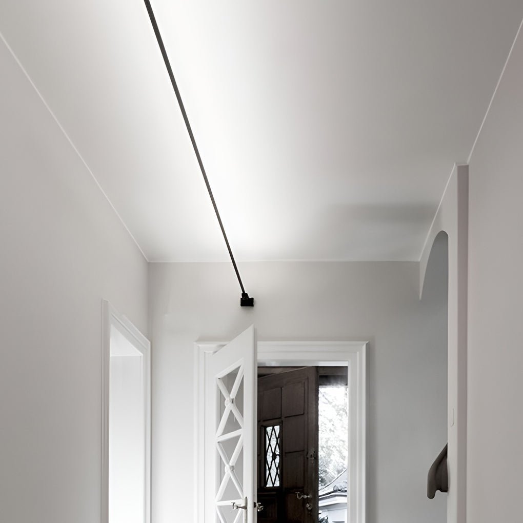 A black Clérachic strip light runs from the top corner of a hallway down to a bracket above a white panelled door.