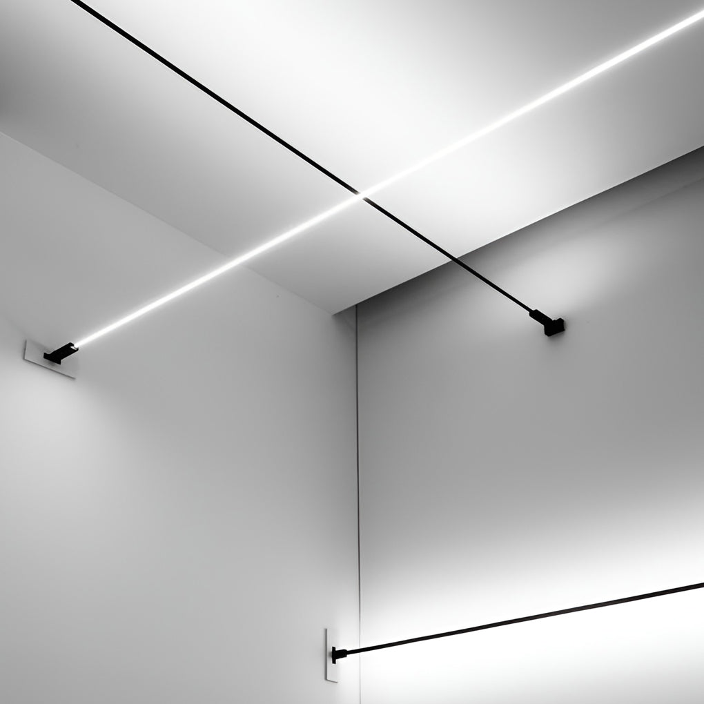 Two Clérachic strip lights cross in the corner of a white room, one lit and one black, each held by a wall bracket.