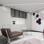 A Clérachic strip light crosses the ceiling of a living area with a brown lounge chair and hexagonal pink-and-plum wall tiles.