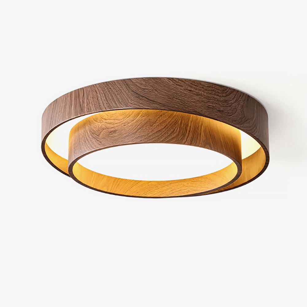 This Clérachic flush ceiling light on a white backdrop, with two stacked walnut wood-grain rings and a warm glow inside the lower ring.