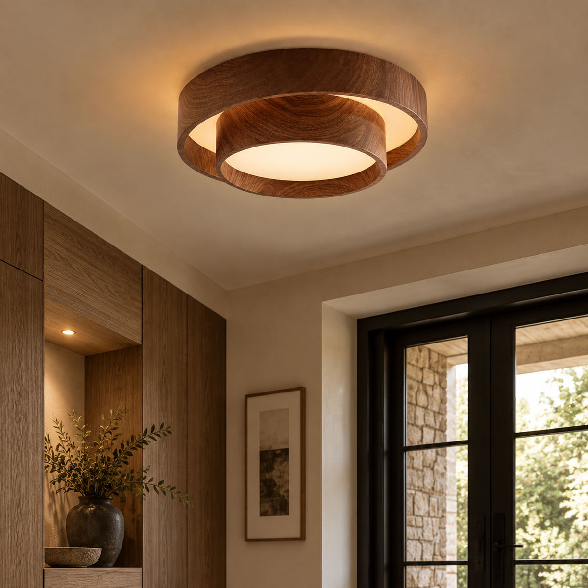 Clérachic ceiling light with a white shade inside walnut-look rings, over a room with wooden wall panels and a glazed door onto a garden.