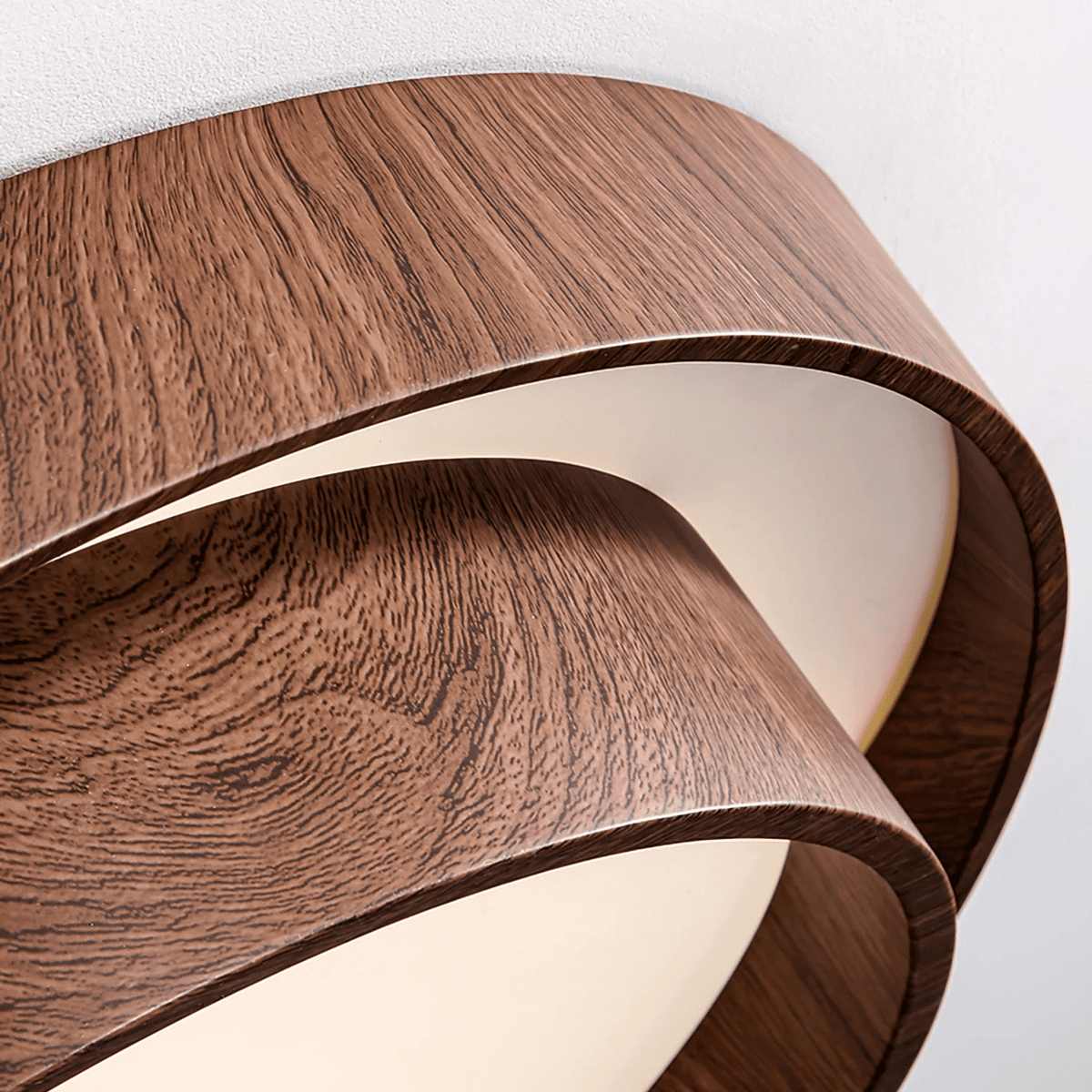 Close view of the fine walnut grain pattern and curved edge of the stacked rings on this Clérachic ceiling light.