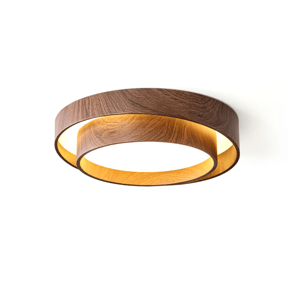 Lit Clérachic ceiling light on a white backdrop, with a golden-oak glow inside the lower ring below the walnut-look outer ring.