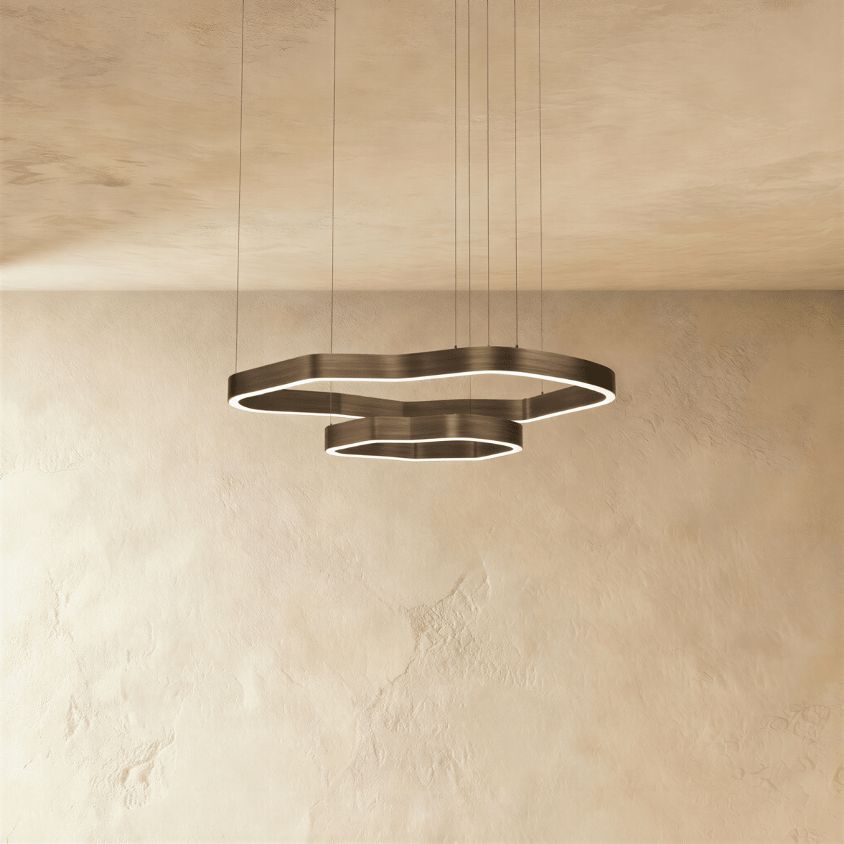 Clérachic two-ring LED chandelier with irregular wavy rings in dark bronze metal, glowing softly on fine suspension cables.