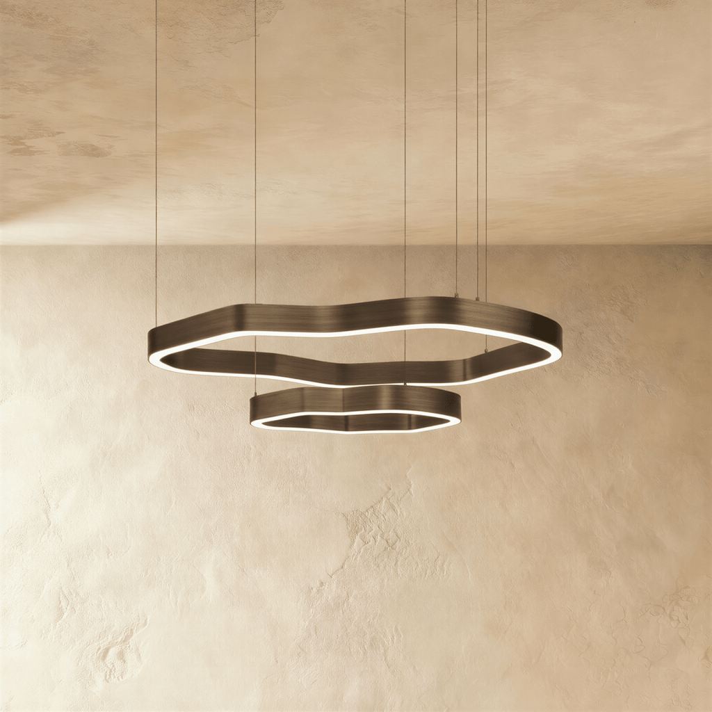 Clérachic large two-ring LED chandelier, wavy bronze-toned rings with a lit inner edge, hanging below a textured plaster ceiling.