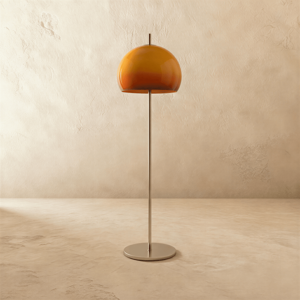 Clérachic floor lamp with an amber-orange glass dome, unlit, on a thin brushed chrome stem and round base.