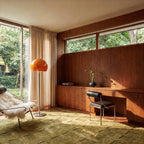 Clérachic floor lamp with an orange glass dome by a sheer curtain and a tall window in a walnut-panelled room.