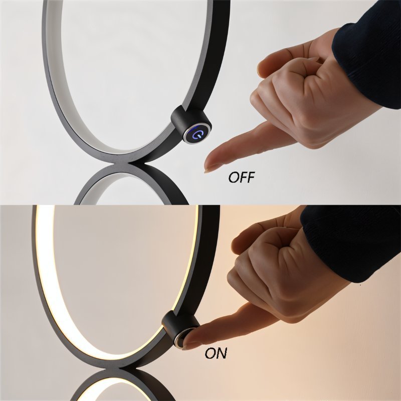 Close up of a hand touching the round switch on a Clérachic black ring floor lamp, shown off above and lit below.