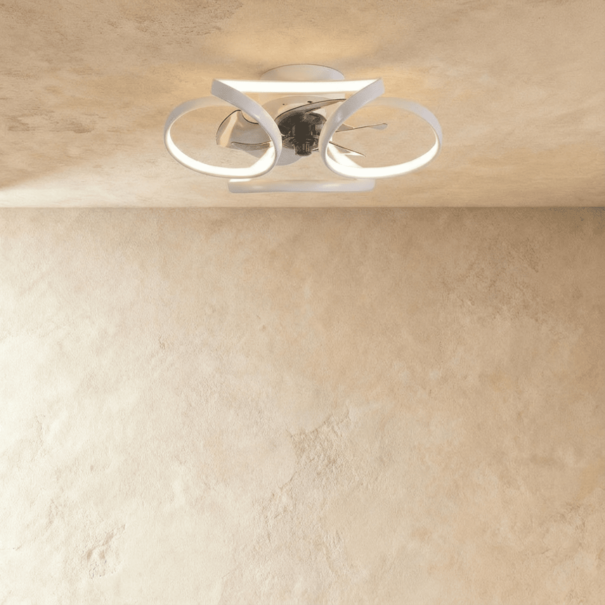 Clérachic ceiling fan with a light in white: interlocking looped LED bands around a central fan, seen in a studio.