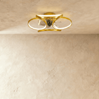 Clérachic ceiling fan with a light in gold, looped LED bands glowing warm around a small central fan in a studio.