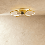 Clérachic larger gold ceiling fan with a light, wide looped LED bands around the central fan in studio light.