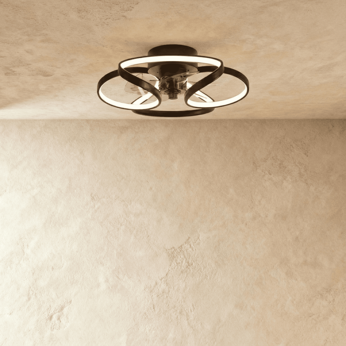 Clérachic ceiling fan with a light in black, with glowing looped LED bands wrapped around a central fan, in a studio.
