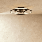 Clérachic larger black ceiling fan with a light in studio view, wide looped LED bands around the fan and warm light above.