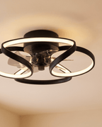 Close up of the Clérachic black ceiling fan with a light: matte black looped LED bands, clear blades and a central fan motor.