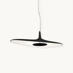 A black flat disc pendant with a white inner surface and a dark central plate hangs on a thin cable against a plain white backdrop, this Clérachic LED pendant.