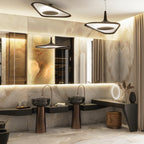 A black pendant with a bright white underside hangs in a marble-walled washroom with twin copper basins and a lit mirror, from Clérachic.