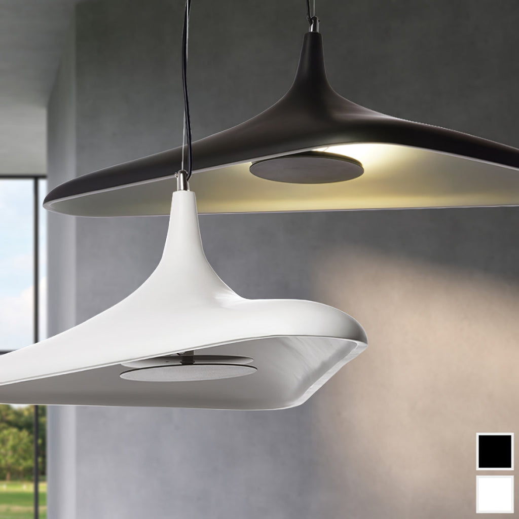 A black and a white disc pendant hang side by side against a grey wall, with the glowing inner surfaces visible, shown as this Clérachic pendant.