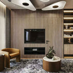 Two white triangular-edged disc pendants glow above a timber-slat wall with a television and a tan armchair, shown with this Clérachic pendant.
