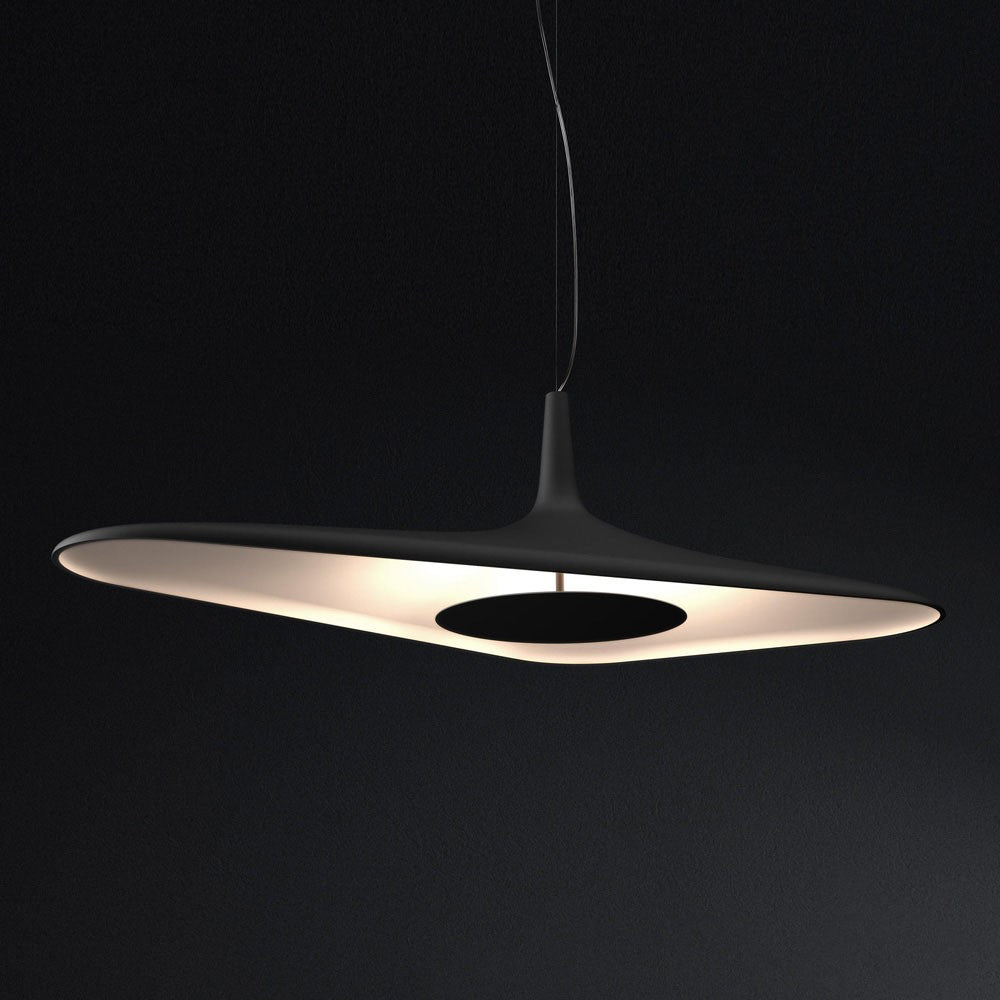A black disc pendant glows with warm light on its underside against a dark black backdrop, shown as this Clérachic LED pendant.