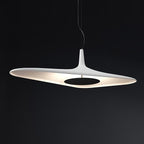 A white disc pendant with a black centre plate glows against a dark backdrop, its lit underside showing, from Clérachic.