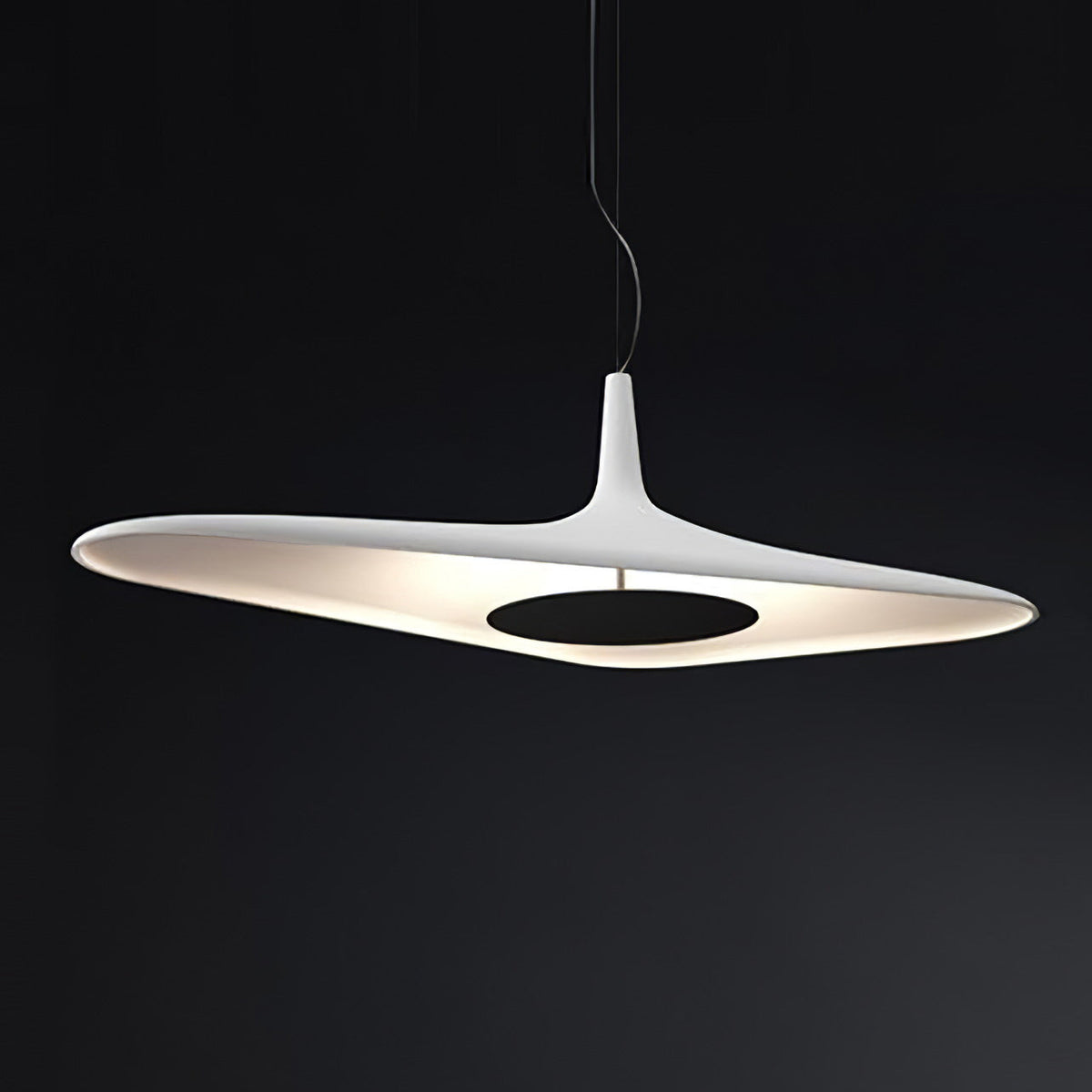 A white disc pendant with a black centre plate glows against a dark backdrop, its lit underside showing, from Clérachic.