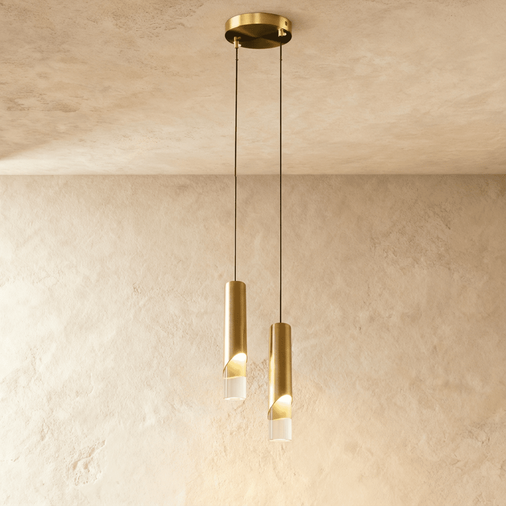 Clérachic two-head gold cylinder pendant with lit clear glass tips, hanging at staggered heights from a round gold plate.