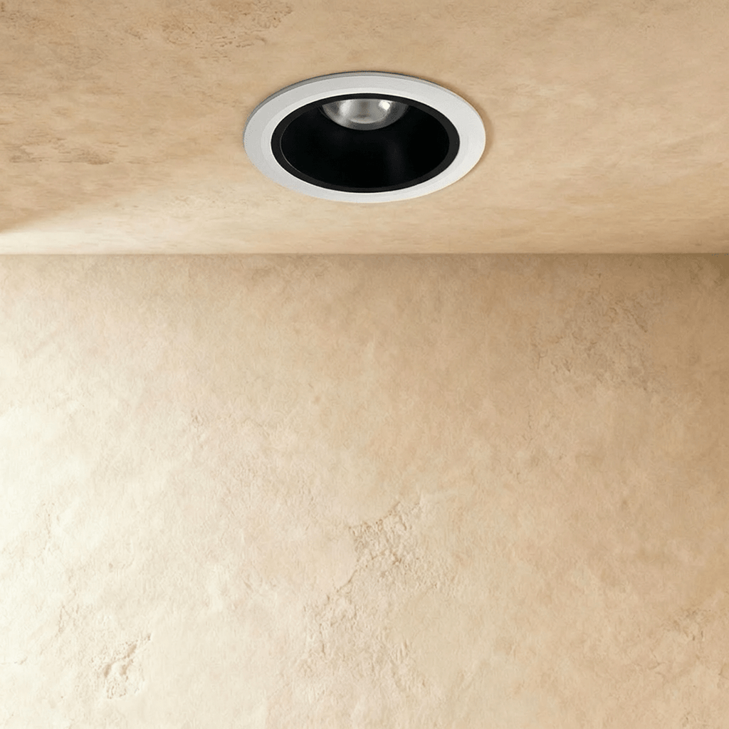 Clérachic recessed downlight switched off, showing a white trim ring around a matte black cone and a small silver reflector.