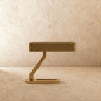 Clérachic brass table lamp unlit, a long flat grilled head on an angled Z arm above a rounded rectangular base.
