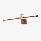 A Clérachic linear wall light on a plain pale backdrop, with a walnut-toned tube, a brass folding arm and a square walnut wall block.