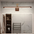 This Clérachic linear wall light runs above a large mirror in a marble-tiled bathroom, with open shelves and a towel rail beside it.