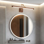 Above a round backlit mirror in a grey-tiled bathroom, this Clérachic linear wall light casts warm light along its walnut tube.