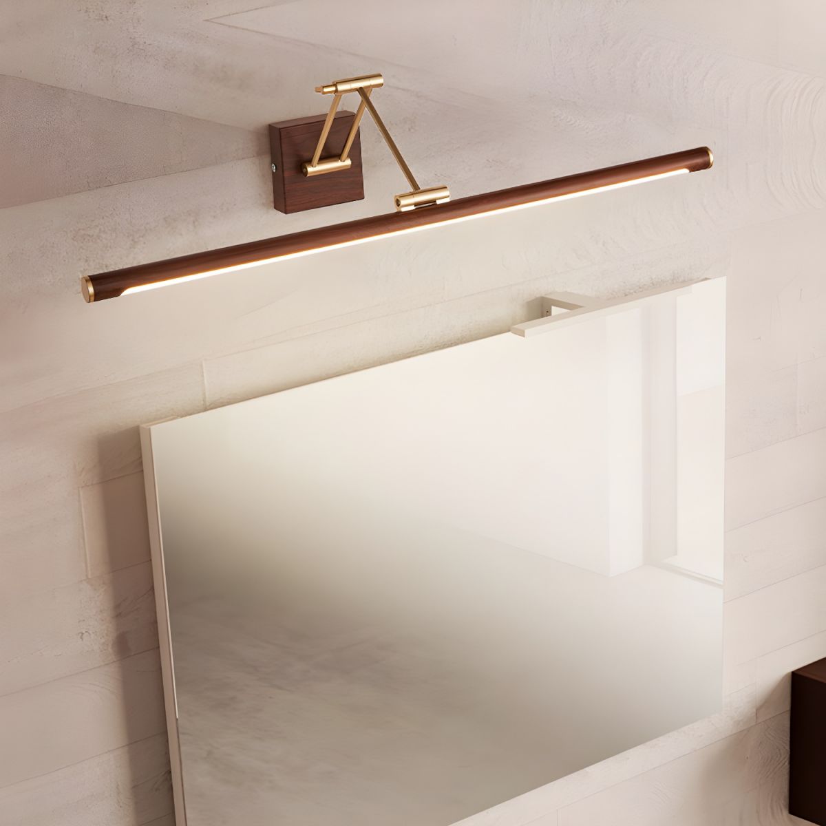 Angled view of this Clérachic linear wall light tilted above a frameless mirror, its lit underside glowing on a pale marbled wall.
