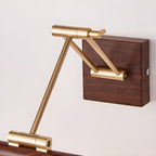 Close view of the brass folding arm, hinge joints and square walnut wall block on this Clérachic linear wall light.