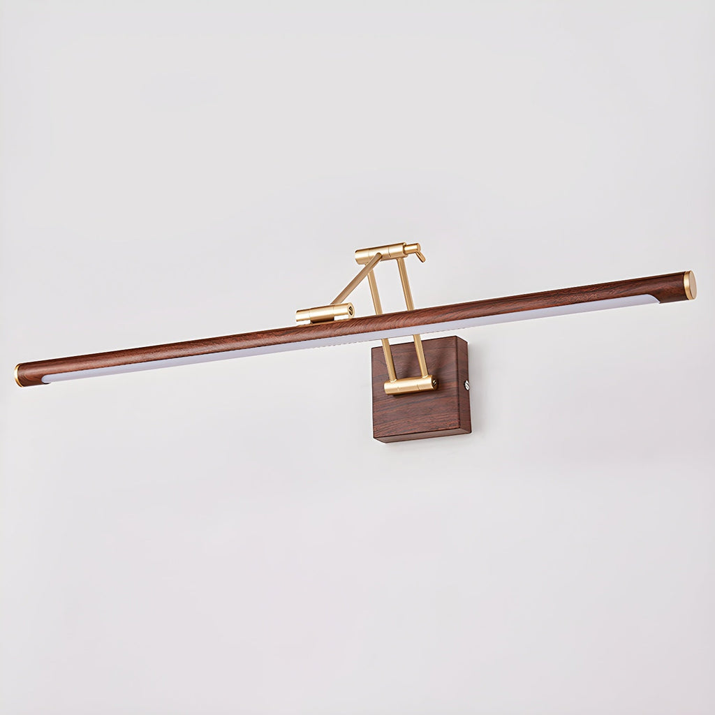 This Clérachic linear wall light on a pale grey wall, with its walnut tube tilted slightly on a brass arm and square wall block.