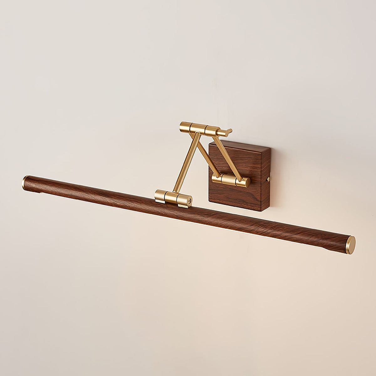 Unlit, angled view of this Clérachic linear wall light on a cream wall, with a brass arm folded over a walnut wall block.