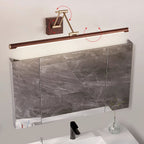Clérachic linear wall light above a marble-fronted mirror cabinet, with red arrows marking how the arm and tube swivel.