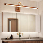 Lit above a mirrored cabinet and a wooden door reflection, this Clérachic linear wall light sits over a vanity with a vase of flowers.