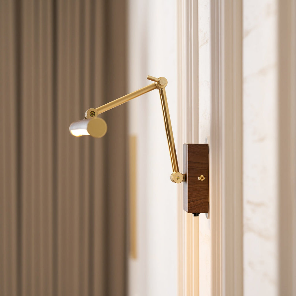 Close view of this Clérachic wall light, its walnut tube turned side-on at the end of a long extended brass arm beside a curtain.